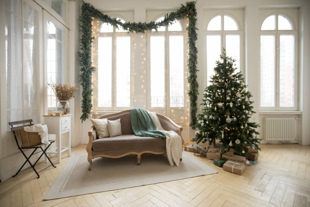 room with light wood floors, christmas tree and couch