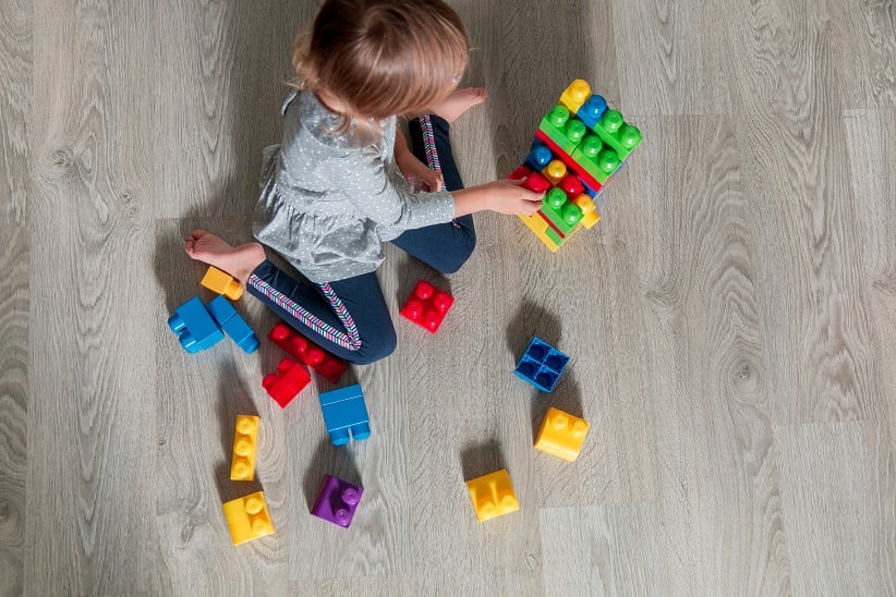 Kid playing with blocks on floor