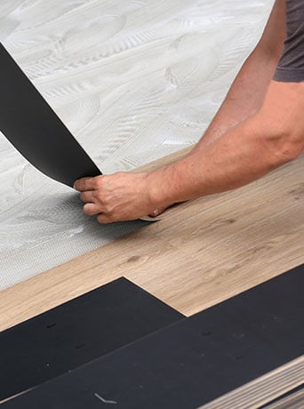 close up photo of a person installing flooring