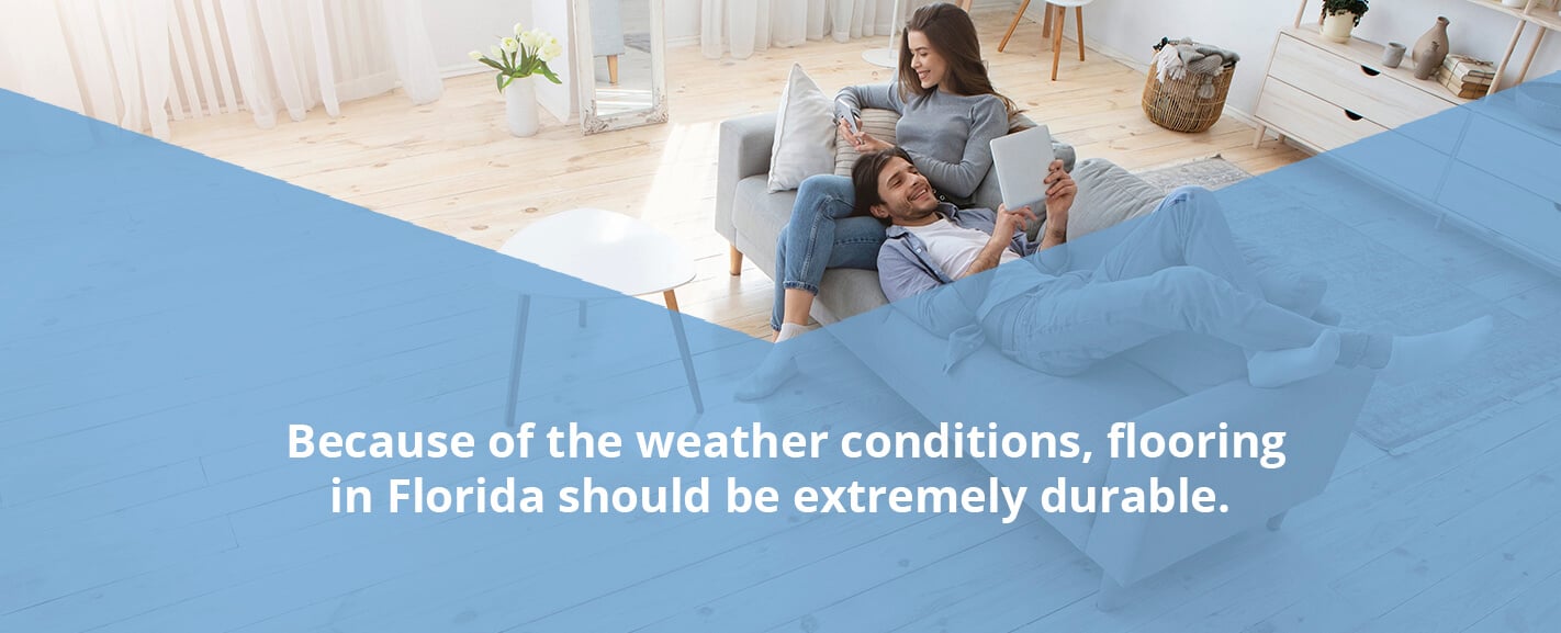 couple sitting on couch in room with wood floors