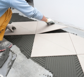 Person installing tile flooring