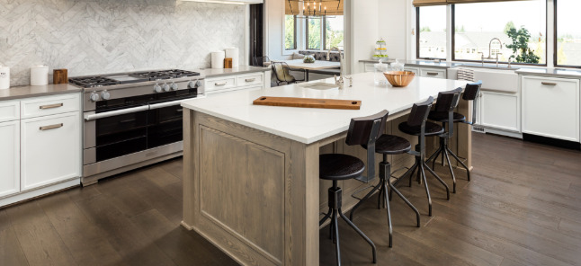 Kitchen with dark wood floors, light wood island and white cabinets