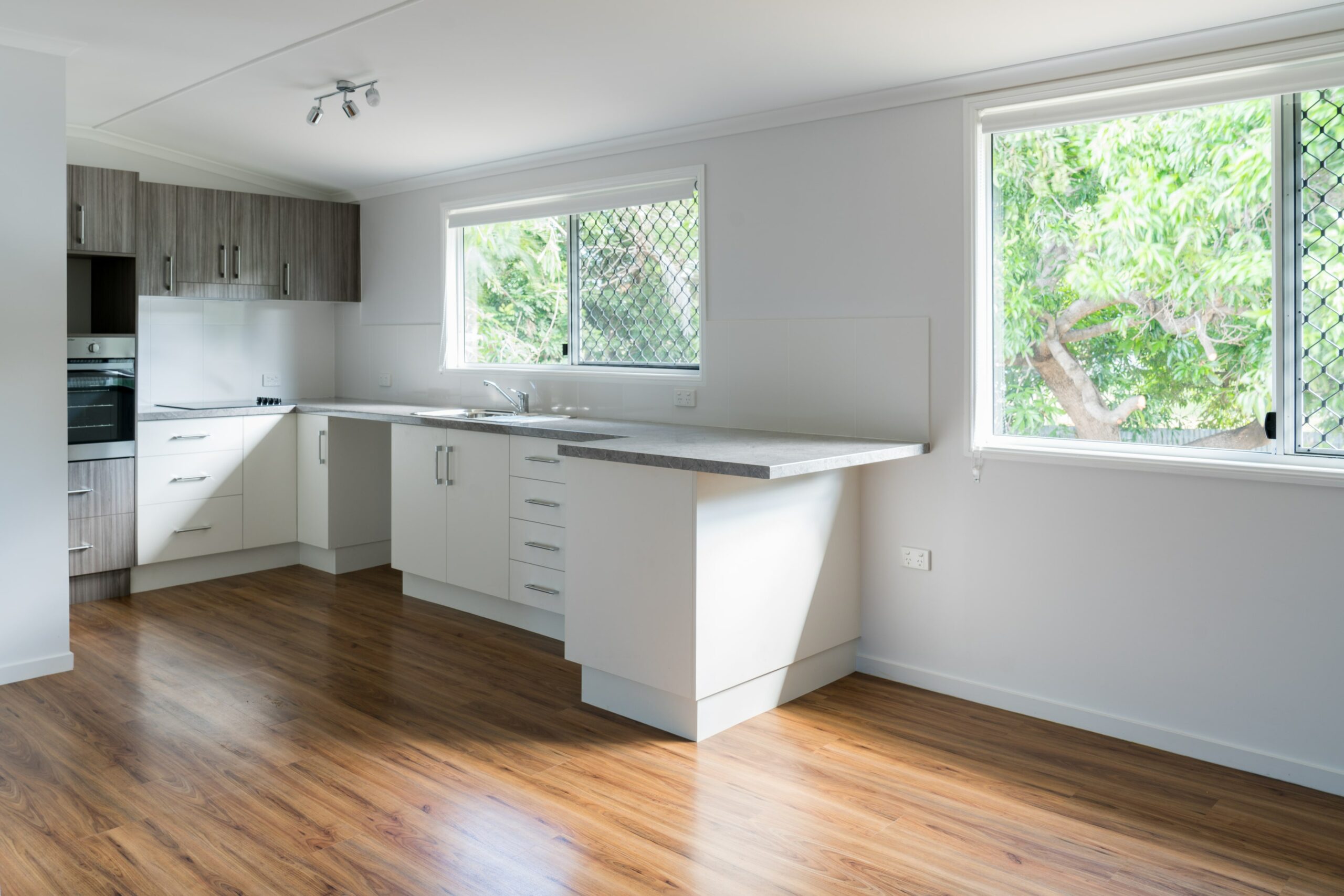 kitchen with wood floors and white and grey cabinets