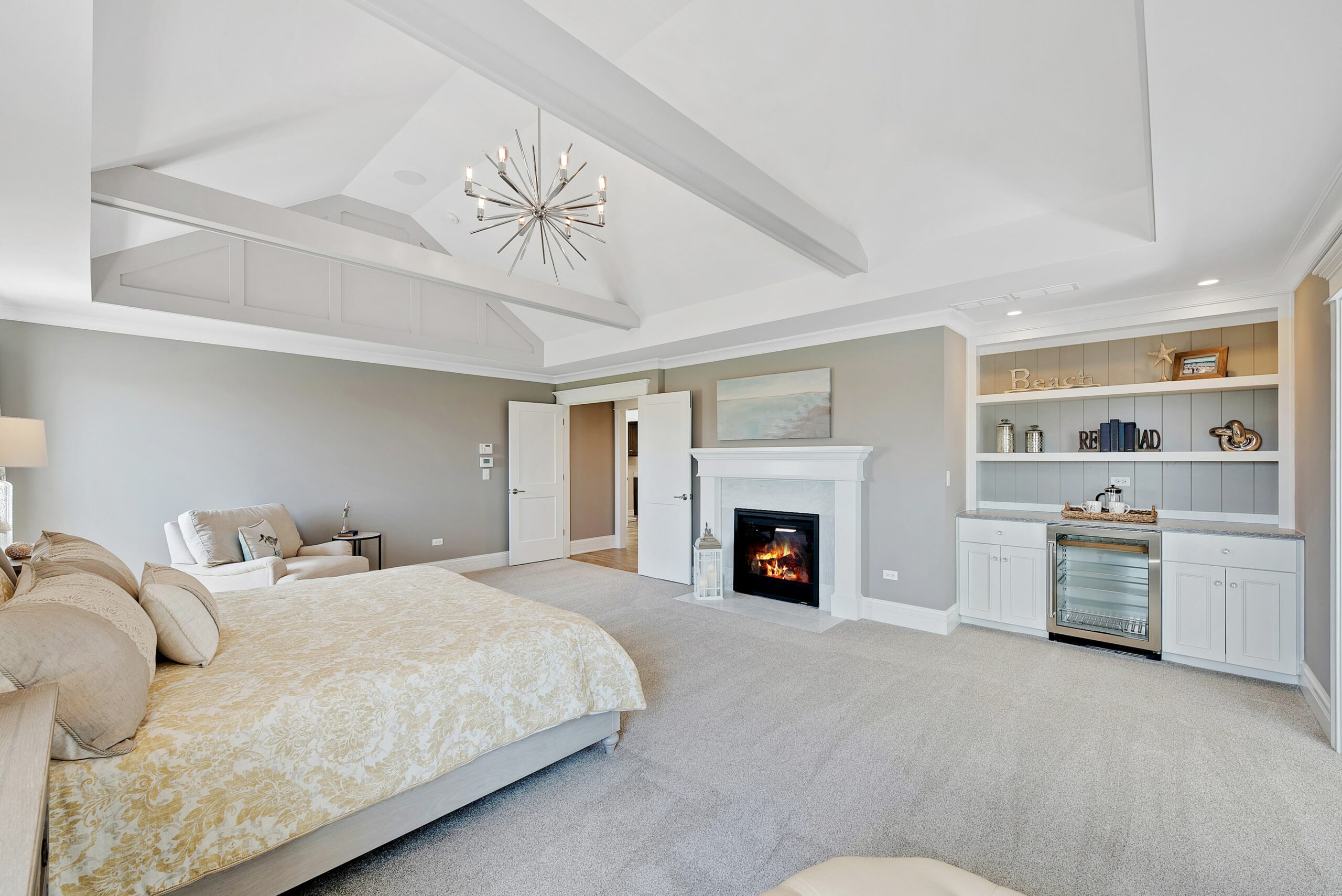 Master bedroom with white carpet and open ceilings and wood beams