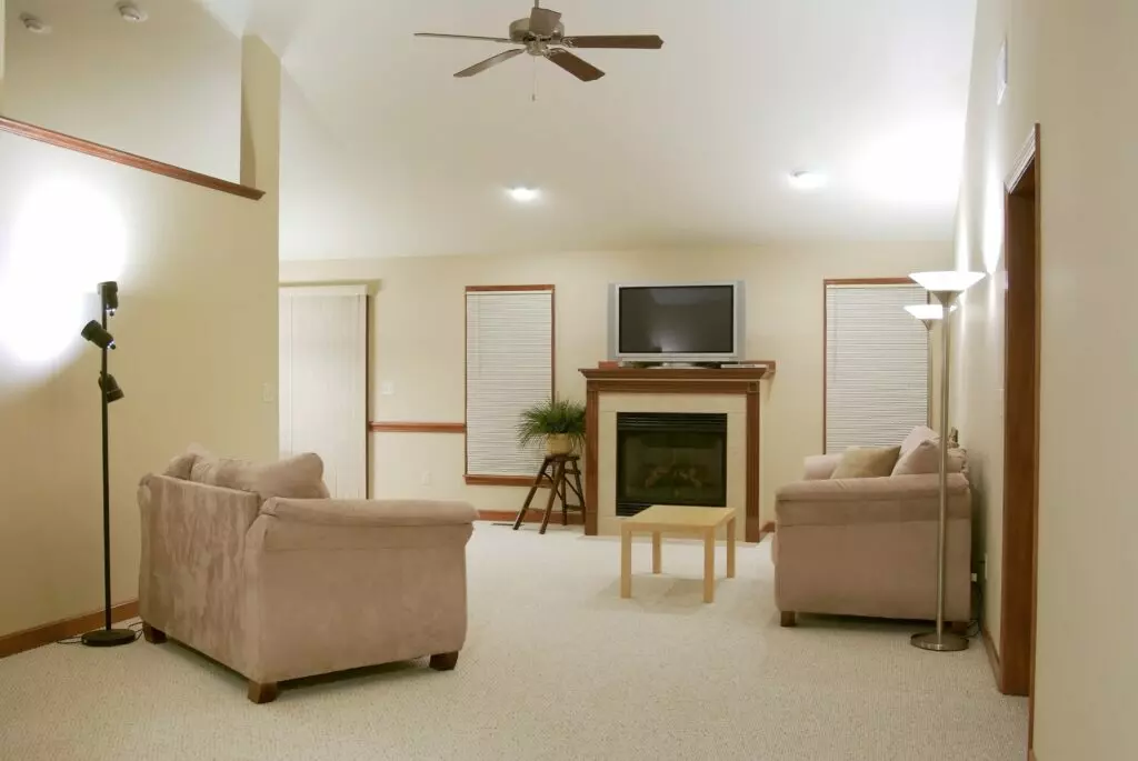 Living room with tan couches and light white carpet floors